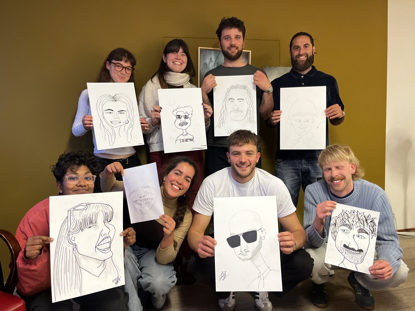Groep deelnemers toont hun karikaturen